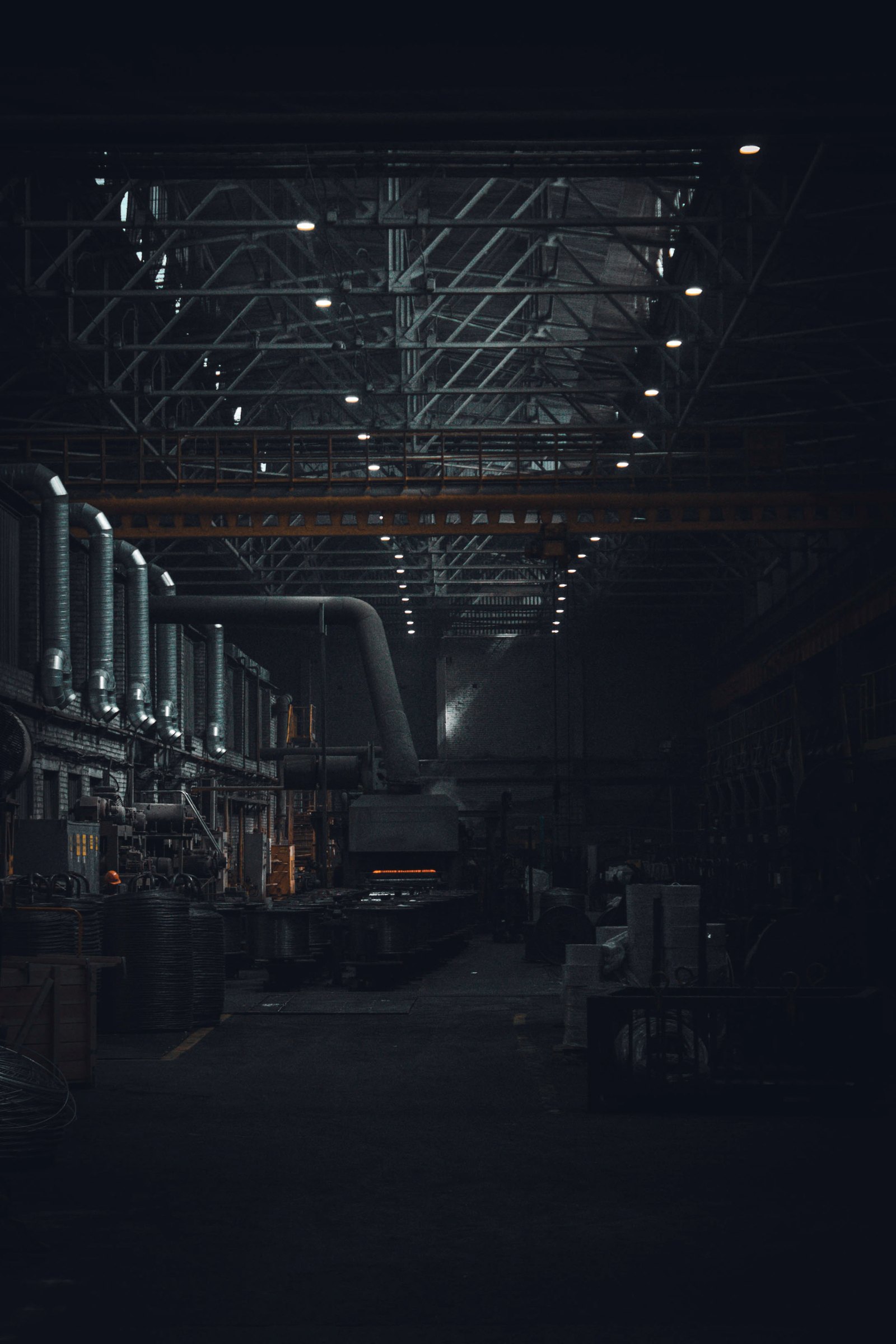 Dark industrial hall under overhead lights